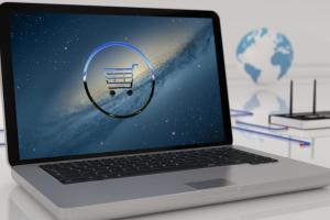 Laptop mit Einkaufswagen-Display auf weißem Tisch