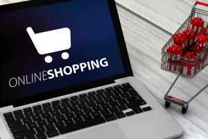 Online-Shopping am Computer mit kleinem Einkaufswagen